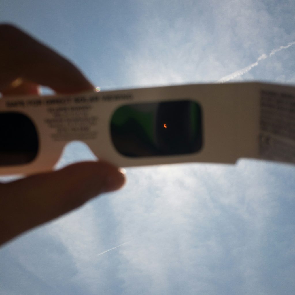 A solar eclipse viewed through solar eclipse glasses.